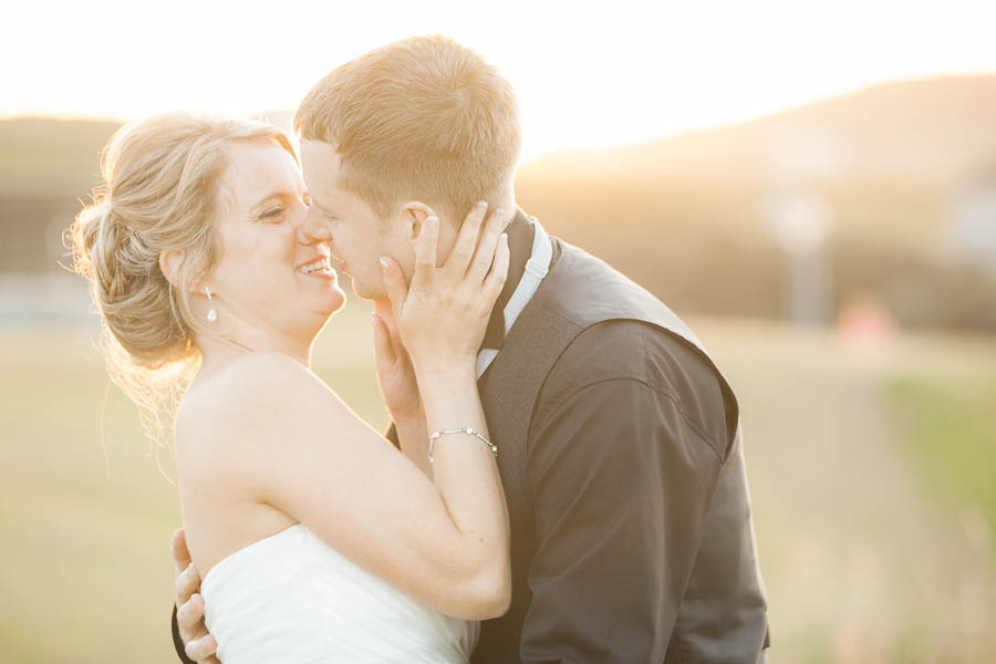 Bride and groom share an intimate moment laughing and kissing