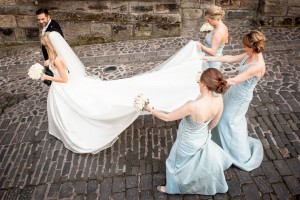 Bride gets plenty of assistance from her bridesmaids to keep her dress clean