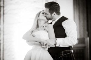 The groom dips his bride and kisses her during their first dance as a married couple
