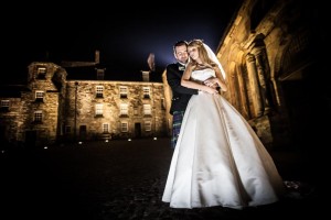groom holding his bride outside of the Stirling Castle Courtyard