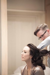 Brides flowing hair is let out as hair stylist works