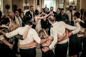 bride and groom dancing with wedding guests surrounding them during last dance of the evening