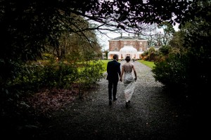 bride and groom walk back towards Marlfield House