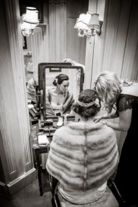 bride getting her makeup touched up before walking outside