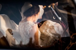bride sits in car gently illuminated by beautiful golden light