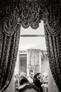 brother of the bride smiles while he is framed in by curtains