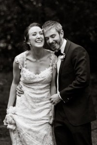 groom and bride are holding each other and laughing so hard their eyes are closed