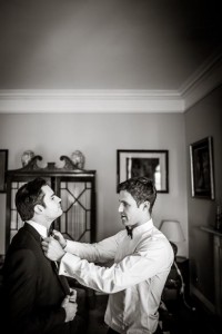groomsmen helping each other getting ready