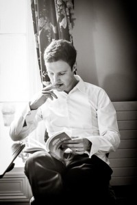 groomsmen reads while groom gets ready