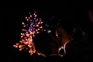 the bride and groom kissing during the fireworks on their New years eve wedding