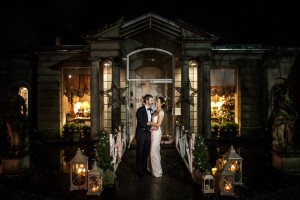 the bride and groom smile at each other in front of Marlfield House at night