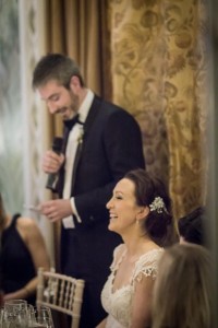 the bride laughs as her new husband gives his speech
