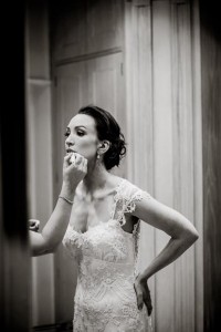 the elegant bride leans forward as she gets her lip gloss put on