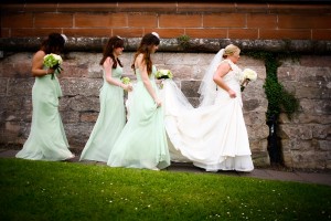 bridesmaids help bride with train on dress