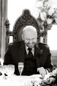 groom laughs at wedding speeches