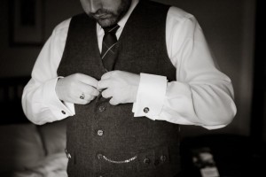 scottish groom gets ready buttoning waistcoat