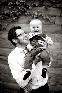man and baby smile at wedding