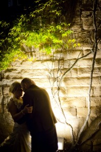 bride and groom outside in dark beside tree