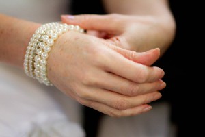bride adjusts pearl bracelet