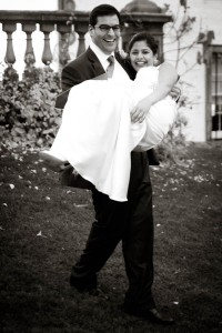 groom carries wife in black and white