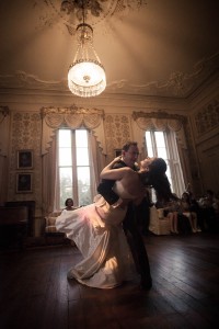 bride and groom dance beneath chandelier at wedding ceilidh at drummuir castle