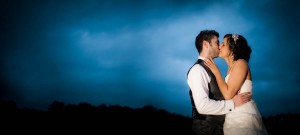 bride and groom kiss outside at dusk