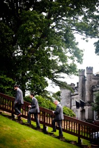 groom and groomsmen climbing steps in grounds of solsgirth house