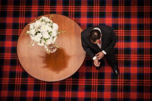 groom and flowers on tartan carpet from above