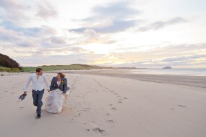 bride and groom make footprints in sand at beach wedding