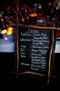 drinks menu on blackboard and candles at log cabin wedding