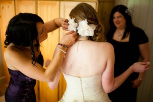 bridesmaid fixes bride's hair