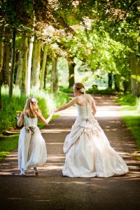 bride and flowergirl go to wedding through wood