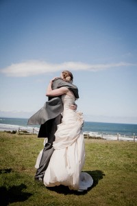 bride and groom embrace at beach wedding