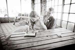 bride and groom sign wedding register at Ravensheugh log cabin