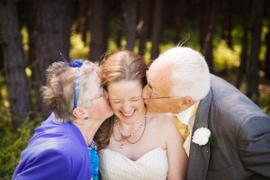 bride kisse by parents at beach wedding