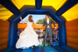bride and groom on bouncy castle at wedding