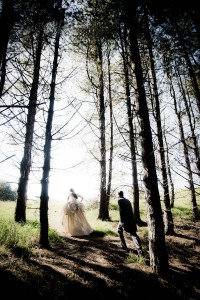 bride and groom walk through trees