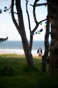 tea lights in jam jars hung beteen tress at beach weddingt
