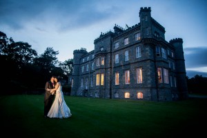 bride and groom outside drummuir castle at dusk