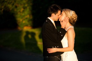 bride and groom kiss outside in sunset