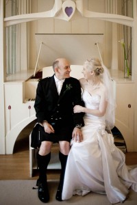 bride and groom on piano stool at house for an art lover in glasgow