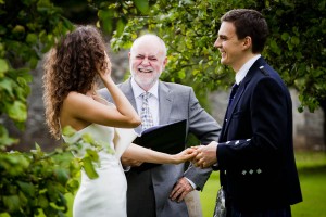 bride and groom with celebrant in garden of traquair house