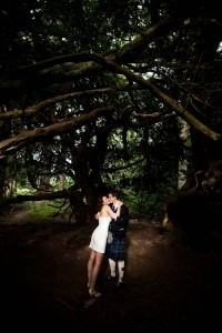 bride and groom under large tree