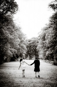 bride and groom walking through avenue of trees
